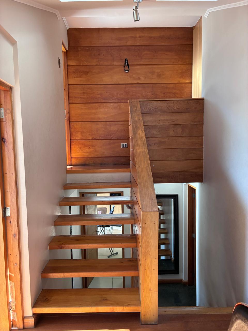 Escalera de madera que conecta los niveles de la casa